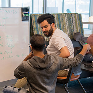 Students studying in front of a white board