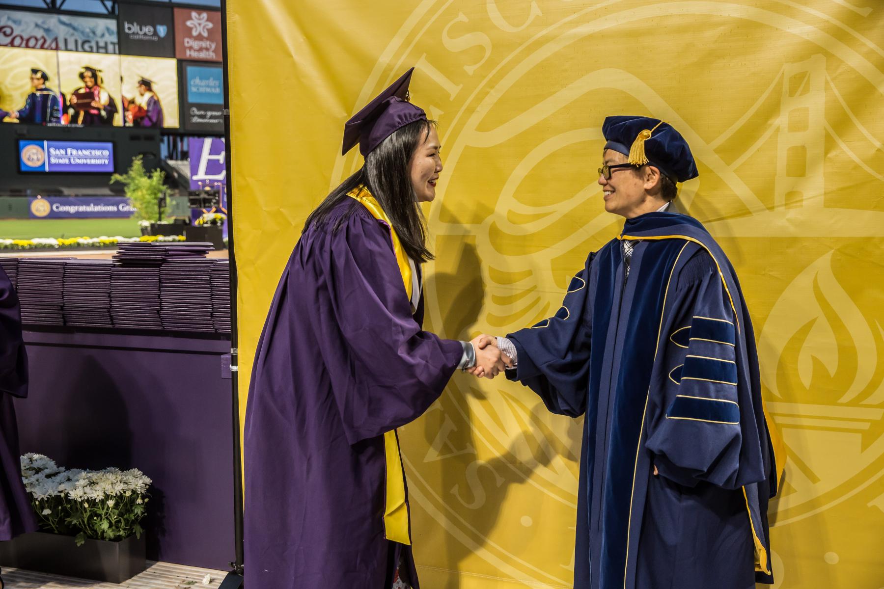 Graduating student shaking hands with Dean Amy