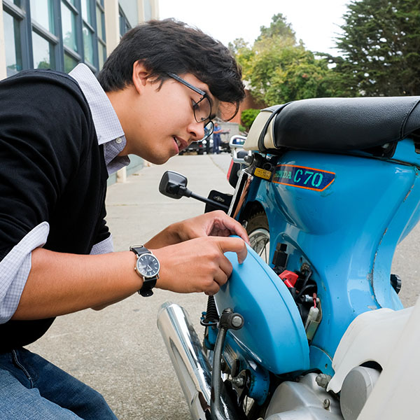 Student working on motorcycle 