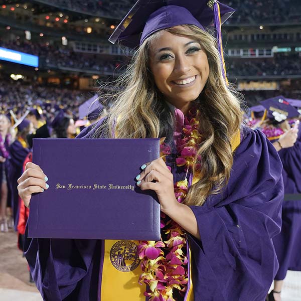Student holding her degree at graduation