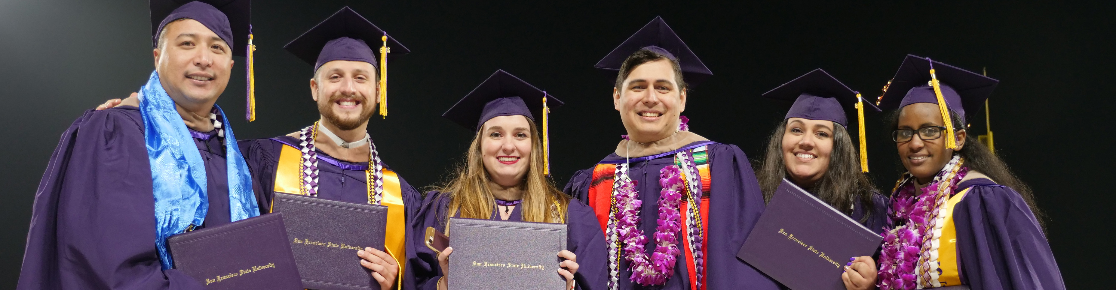 SF State students holding their diplomas at Commencement