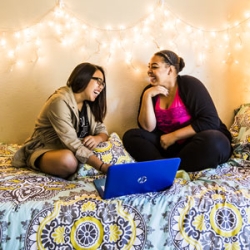 May De Luna and Andrea Gamboa on a bed talking