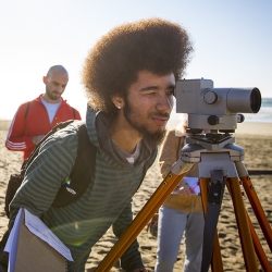 Student looking through a camera lens