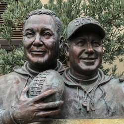 memorial statue two men holding a football